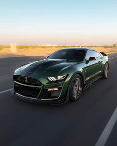 a green sports car driving down the road