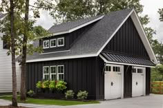 a black and white house with two garages