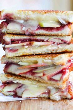 four grilled sandwiches stacked on top of each other with fruit toppings and melted cheese