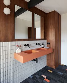 a bathroom with two sinks and mirrors on the wall