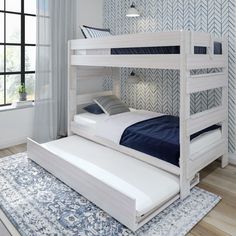 a white bunk bed sitting on top of a wooden floor next to a blue rug