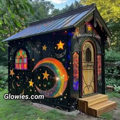 a small building with an open door and stars on the side, painted in rainbow colors