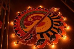 an intricately decorated diya with candles on the ground