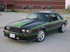 a black and green car parked in front of a building