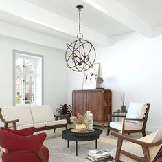 a living room filled with furniture and a chandelier hanging over the top of it