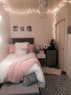 a bedroom decorated in pink and grey with lights