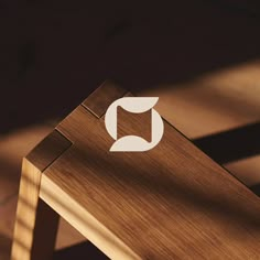 a close up of a wooden table with a white logo on the top and bottom