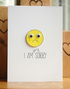 a card with a smiley face on it and the words i am sorry written in black