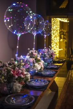 the table is set with plates and flowers on it, while balloons are floating in the air