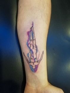 a man's foot with a tattoo on it that has a praying hand in the middle