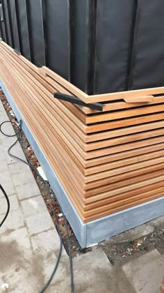 a large wooden box sitting on top of a cement ground next to a brick wall