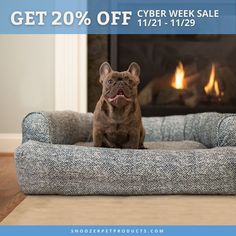 a dog is sitting on his bed in front of the fire place and sale sign