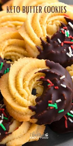 chocolate covered cookies with sprinkles are on a plate and the words keto butter cookies above them