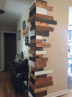 a wall made out of wooden planks in a living room next to a table