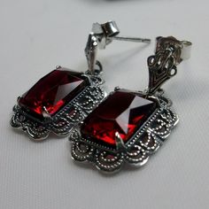 Simulated Red Ruby Solid Sterling Silver Earrings Short Festoon Design#E8z (shorter version) These Victorian reproduction estate earrings are solid sterling silver. These filigree earrings have stunning simulated red ruby gemstones. Each stunning gem is 10mm x 8mm x 5mm in dimension. The earrings are approximately 1/2" x 1" (13mm x 23mm). The unique earrings are marked 925 for solid sterling silver. These lovely earrings were refashioned from an antique Victorian cameo necklace. Quintessentially Classic Red Earrings For Party, Classic Red Party Earrings, Red Sterling Silver Earrings For Wedding, Red Classic Jewelry With Matching Earrings, Classic Red Jewelry With Matching Earrings, Classic Red Nickel-free Earrings, Classic Red Dangle Earrings, Classic Red Sterling Silver Earrings, Formal Red Hypoallergenic Jewelry