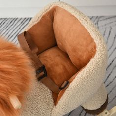 a dog bed with a furry ball on the floor next to it and a stuffed animal