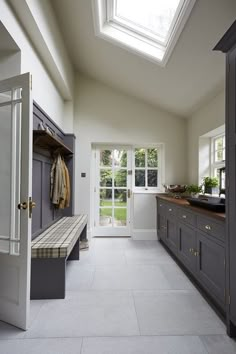 a kitchen with an open skylight above the sink and counter top, along with two doors leading to another room