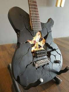 an electric guitar that has been broken and is sitting on top of a wooden table