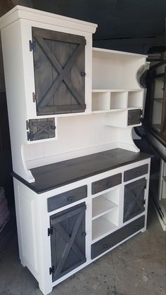 a kitchen with white cabinets and black counter tops