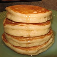 a stack of pancakes sitting on top of a green plate