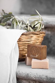 two bars of soap sitting next to a basket