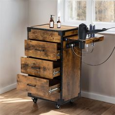 a wooden cart with drawers and bottles on it in front of a window, next to a bottle opener