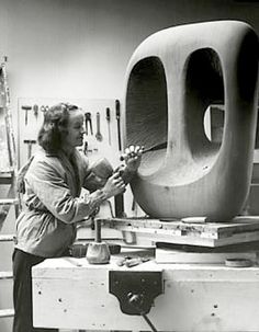 an older woman is working on a sculpture