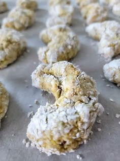 powdered sugar covered donuts sitting on top of a baking sheet, ready to be eaten