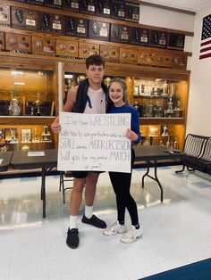 a man and woman holding up a sign