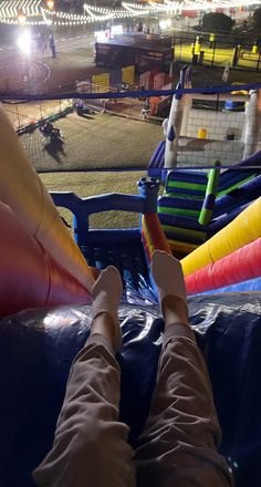 the person is sitting on an inflatable slide