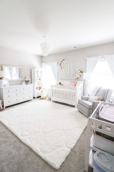 a baby's nursery with white carpet and furniture, including two cribs