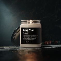 a candle with the label ring man on it sitting on a table in front of a dark background