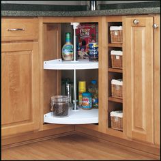 an open cabinet in the corner of a kitchen