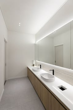 a bathroom with two sinks and mirrors in it