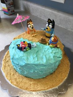 a cake decorated with blue frosting and cartoon characters