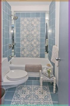 a bathroom with blue and white tiles on the walls, flooring and bathtub