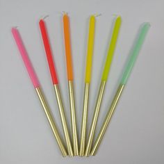 five different colored straws are lined up in a row on a white table top