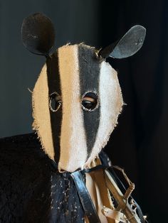 a stuffed animal wearing a black and white striped mask with horns on it's head