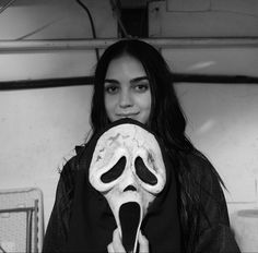 a woman holding a fake skull in front of her face