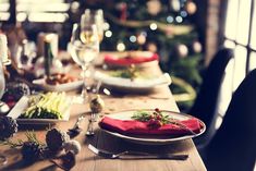 a table set for christmas dinner with plates and silverware