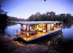 a houseboat is floating on the water at night with its deck lit up and covered in lights