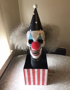 a creepy clown mask sitting on top of a box