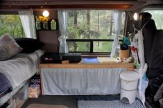 the inside of a camper with two beds and a table in front of it