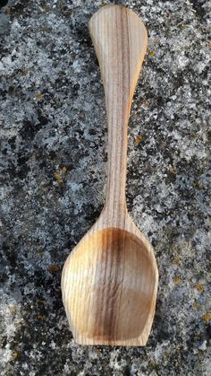 a wooden spoon sitting on top of a rock