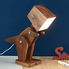 a wooden desk lamp sitting on top of a table