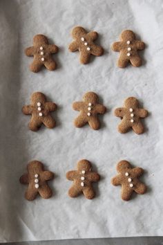 gingerbreads with white pearls are arranged on a sheet of wax paper