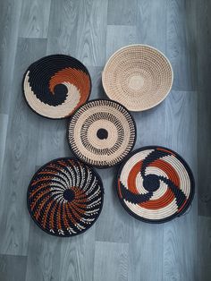 four woven baskets sitting on top of a wooden floor