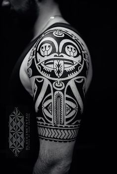 a black and white photo of a man's arm with an intricate tattoo design on it