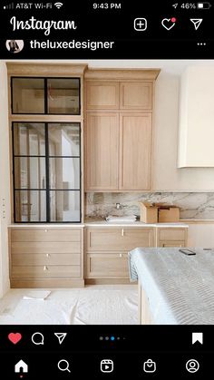 an instagram photo of a kitchen with wooden cabinets and white sheets on the bed