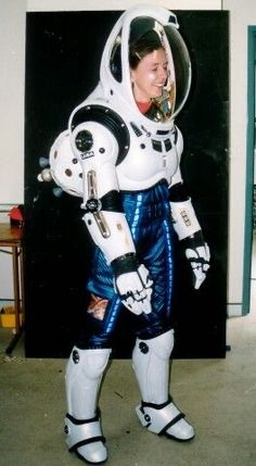 a man dressed as a spaceman standing in front of a wall